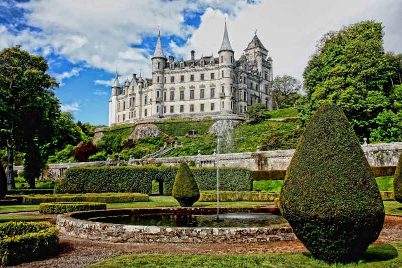 white concrete castle surrounded by green plants