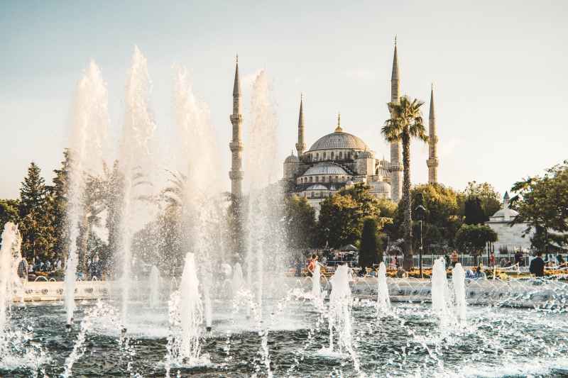 water fountain near white concrete dome building under white sky